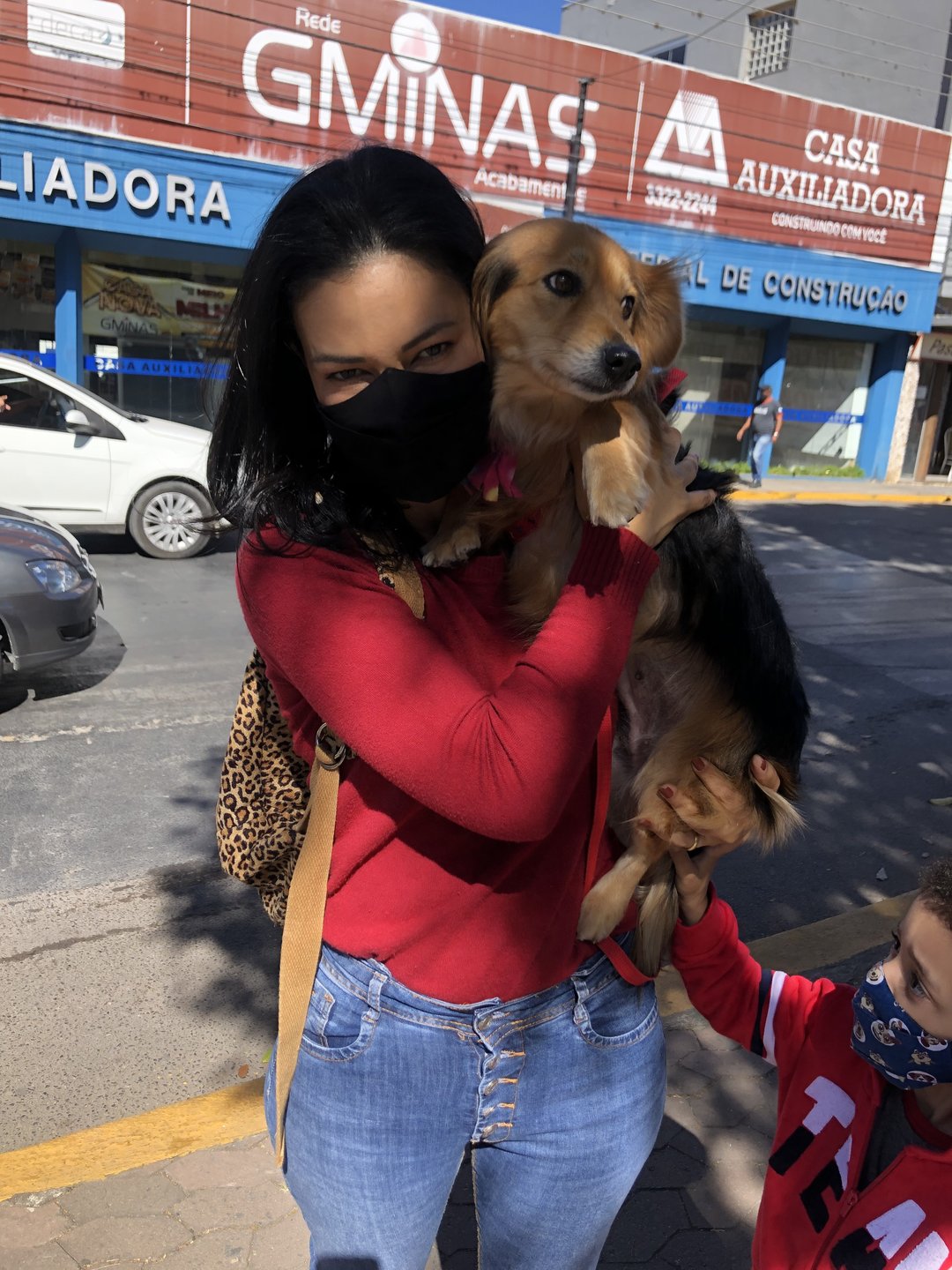Joice Alvarenga carregando um cachorro em ação pela causa animal