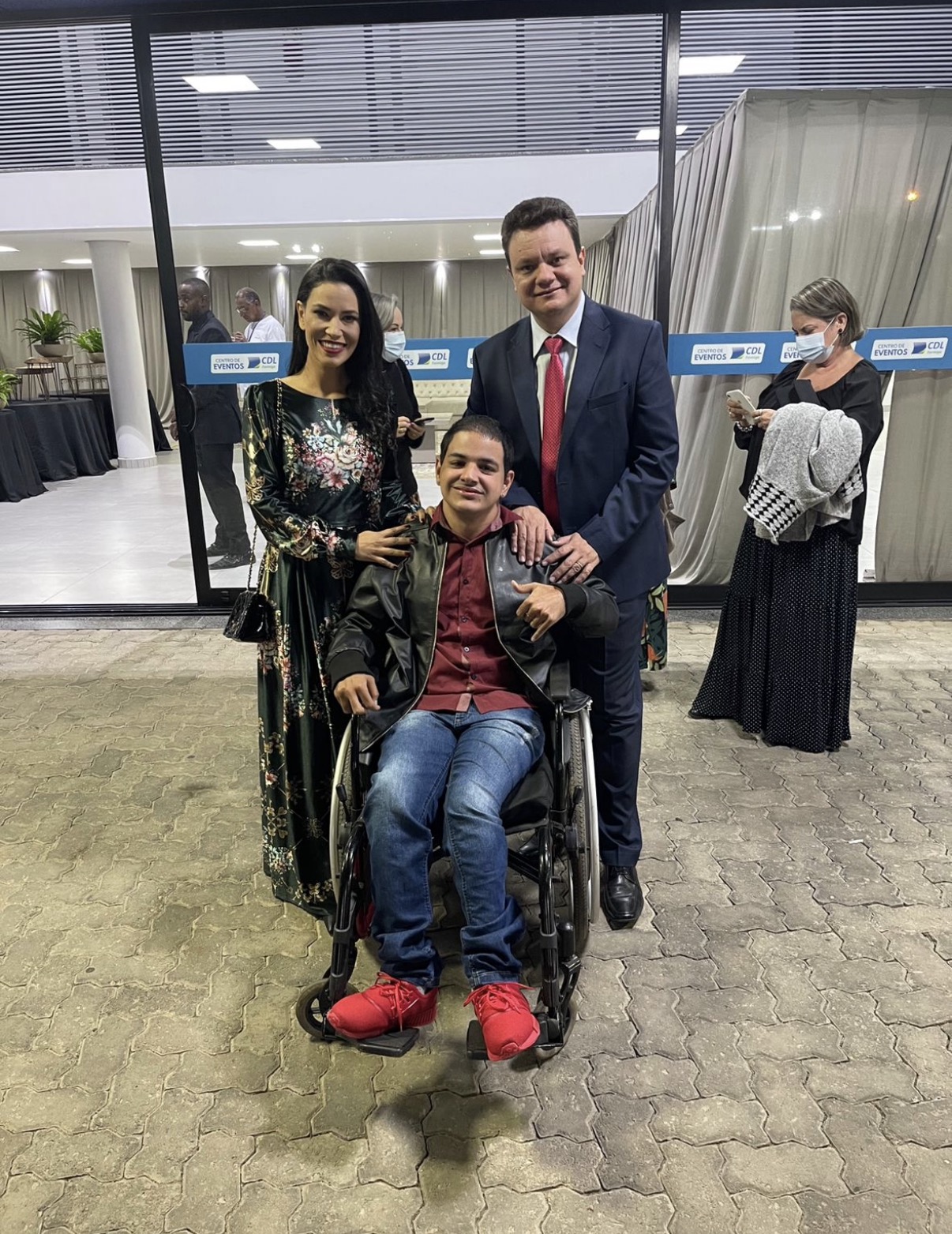 Joice Alvarenga com um jovem em cadeira de rodas em evento de inclusão